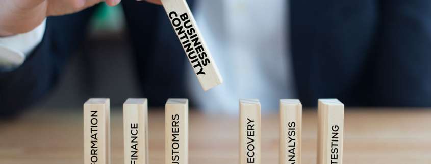 Bausteinreiche und Hand setzt Mittelstück mit BCM Beschriftung