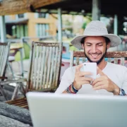 Mann mit Hut vor Laptop
