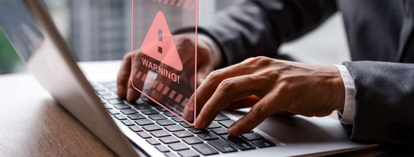 Laptop mit rotem Warning Schild über der Tastatur