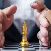 Hände schützen eine Schachfigur. Symbolisiert Risikomanagement.