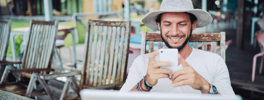 Mann mit Hut vor Laptop