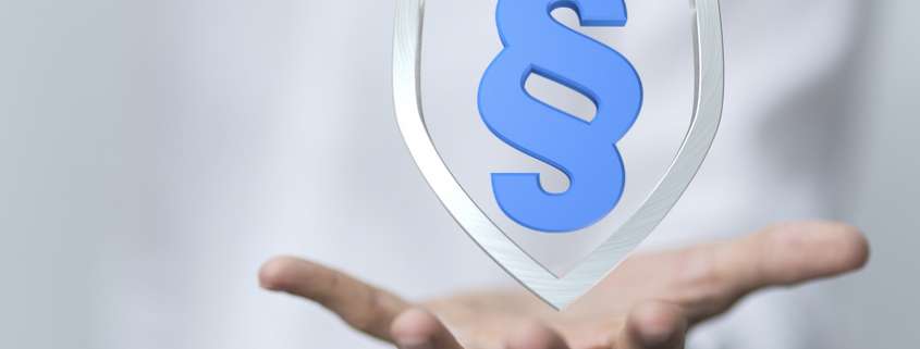 Schild mit Paragraphenzeichen schwebt über einer Hand